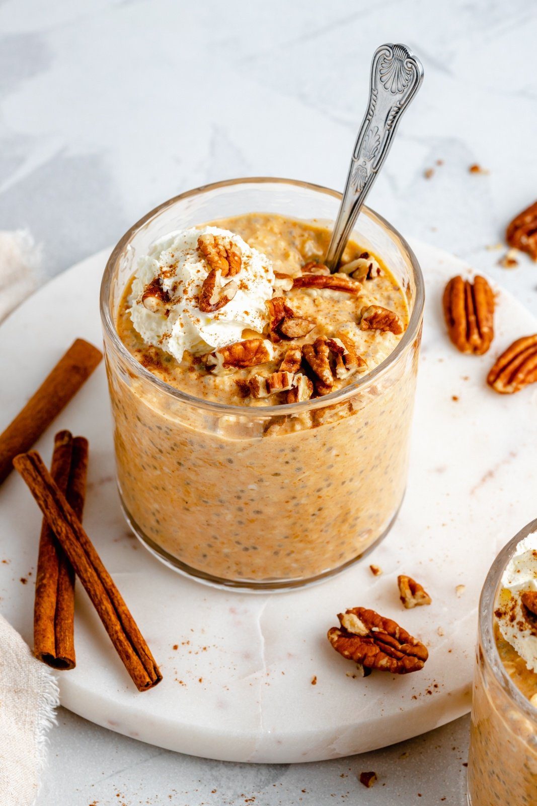 Pumpkin Overnight Oats in a jar with pecans and cinnamon sticks